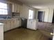 Kitchen featuring dated cabinetry with adjacent dining area, offering a view into an adjacent living room at 4032 Chaucer Dr, Durham, NC 27705
