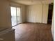 View of a living room with worn wood floors, sliding patio doors, and a closet at 4032 Chaucer Dr, Durham, NC 27705