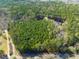 Expansive aerial view of a secluded property surrounded by lush greenery and mature trees, offering privacy and natural beauty at 422 Lower Thrift Rd, New Hill, NC 27562