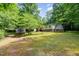 Wide shot of the backyard highlighting the lush lawn and wooded surroundings at 441 Wintergreen Rd, Timberlake, NC 27583