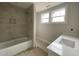 Bright bathroom featuring tiled bathtub and modern single vanity at 4889 Grosbeak Ct, Mebane, NC 27302