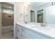 Bright bathroom featuring double sinks, modern fixtures, and tiled shower at 4889 Grosbeak Ct, Mebane, NC 27302
