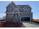 Charming two-story home with stone accents, a covered porch, and an attached two-car garage at 4889 Grosbeak Ct, Mebane, NC 27302