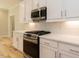 Modern kitchen featuring white cabinets, stainless steel appliances, and quartz countertops at 4889 Grosbeak Ct, Mebane, NC 27302