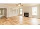 Spacious living room with hardwood floors, fireplace, built-in shelving, and large windows at 4889 Grosbeak Ct, Mebane, NC 27302