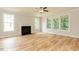 Bright living room with hardwood floors, fireplace, and large windows overlooking the exterior at 4889 Grosbeak Ct, Mebane, NC 27302