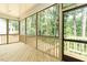 A screened-in porch with wooden floors provides ample views of the surrounding trees at 4889 Grosbeak Ct, Mebane, NC 27302