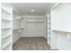 Large walk-in closet with installed shelving, hanging racks, and carpeted flooring at 4889 Grosbeak Ct, Mebane, NC 27302