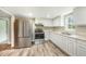 Kitchen features stainless steel appliances, white cabinets, and new flooring at 501 N 14Th St, Erwin, NC 28339