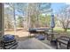 Backyard patio with an outdoor kitchen, dining set, and lots of trees at 5029 Stonewood Pines Dr, Knightdale, NC 27545
