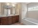 A bathroom featuring double sink vanity with a soaking tub and large window at 5029 Stonewood Pines Dr, Knightdale, NC 27545