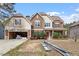 Two-story home with a mix of siding, landscaping, and an attached two car garage in need of repair at 5029 Stonewood Pines Dr, Knightdale, NC 27545