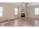 Spacious living room with a fireplace, multiple windows, and wood floors at 5029 Stonewood Pines Dr, Knightdale, NC 27545