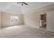 A main bedroom with tray ceiling, ceiling fan, neutral paint, and a large window at 5029 Stonewood Pines Dr, Knightdale, NC 27545