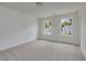 Bright bedroom featuring two windows, neutral carpet, and soothing white walls at 568 Winding Creek Dr, Lillington, NC 27546