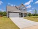 Beautiful two-story home with stone accents, a two-car garage, and a well-maintained lawn at 580 Winding Creek Dr, Lillington, NC 27546