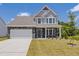 Inviting two-story home with stone accents, a well-manicured lawn, and a two-car garage at 580 Winding Creek Dr, Lillington, NC 27546
