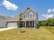 Inviting two-story home with stone accents, a well-manicured lawn, and a two-car garage at 580 Winding Creek Dr, Lillington, NC 27546