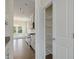 Walk-in pantry with white wire shelving next to a modern kitchen and outdoor living area at 580 Winding Creek Dr, Lillington, NC 27546