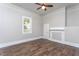 Neutral bedroom featuring hardwood floors, a ceiling fan, and a decorative fireplace mantel at 704 Pender St, Rocky Mount, NC 27801
