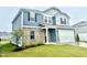 Charming two-story home featuring blue siding, a brick facade, and an attached two-car garage at 768 Riguard Way, Wendell, NC 27591