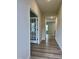 Bright hallway showcasing wood-look flooring, leading to a room with stylish glass paneled doors at 768 Riguard Way, Wendell, NC 27591
