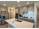 Well-lit kitchen with stainless steel appliances, a large island, and sleek gray cabinetry at 768 Riguard Way, Wendell, NC 27591