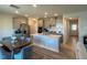 Modern kitchen featuring a large island with seating, stainless steel appliances, and a dining table at 768 Riguard Way, Wendell, NC 27591