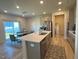 Modern kitchen featuring a large island with seating, stainless steel appliances, and dining area at 768 Riguard Way, Wendell, NC 27591