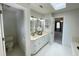 Bright bathroom featuring double sinks, a vanity, and a door leading to the primary bedroom at 7721 Sutcliffe Dr, Raleigh, NC 27613