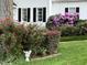 Charming front yard featuring blooming roses and manicured bushes. Adds beauty and curb appeal to the home at 7721 Sutcliffe Dr, Raleigh, NC 27613