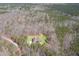 Overhead view of the home nestled in a wooded area surrounded by mature trees and lush greenery at 7936 Nc 42, Holly Springs, NC 27540