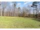 Expansive backyard featuring a grassy lawn and a wooded area, perfect for outdoor activities and enjoying nature at 7936 Nc 42, Holly Springs, NC 27540