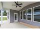 Covered back porch has gray siding, white trim, recessed lighting and ceiling fan at 9173 Dupree Meadow Ct # 25, Angier, NC 27501