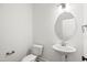A half bathroom featuring a pedestal sink, oval mirror, and modern lighting fixtures at 9173 Dupree Meadow Ct # 25, Angier, NC 27501