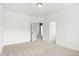 Neutral bedroom with open doors to closet and hallway features neutral carpet and white paint at 9173 Dupree Meadow Ct # 25, Angier, NC 27501