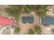Aerial shot of a home with a dark gray roof, surrounded by trees and featuring a red outbuilding at 92 Papoose Trl, Lillington, NC 27546