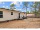 Image of a home's exterior with a backyard including a small outdoor patio and chain-link fence at 92 Papoose Trl, Lillington, NC 27546