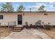View of a backyard with an outdoor patio, seating, brick steps, black door, and an exterior view of a home at 92 Papoose Trl, Lillington, NC 27546