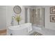 Bright bathroom featuring a free-standing tub, a shower, and a double vanity with granite countertop at 92 Papoose Trl, Lillington, NC 27546