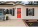 Up close, the bright red front door beckons, with a cozy porch, dark shutters, and tidy landscaping at 92 Papoose Trl, Lillington, NC 27546