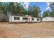 Inviting single-story home with a red door, black shutters, and a well-kept yard with mature trees at 92 Papoose Trl, Lillington, NC 27546