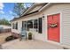 Charming home featuring a bright red front door, front porch, rocking chair, and manicured lawn at 92 Papoose Trl, Lillington, NC 27546
