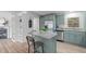 Kitchen island features granite countertop, seating, stainless steel appliances, and custom blue cabinetry at 92 Papoose Trl, Lillington, NC 27546