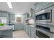 Charming kitchen featuring stainless steel appliances, granite countertops, and custom blue cabinetry at 92 Papoose Trl, Lillington, NC 27546