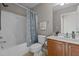 Cozy bathroom featuring a shower-tub combination and wooden vanity with a white countertop sink at 101 Cambridge Way, Oxford, NC 27565
