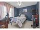 Comfortable bedroom with blue walls, a ceiling fan, a twin bed, and exercise equipment at 101 Cambridge Way, Oxford, NC 27565