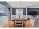 Elegant dining room featuring blue walls, wainscotting, wood floors, and a modern chandelier for memorable gatherings at 101 Cambridge Way, Oxford, NC 27565