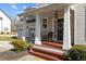 Charming front porch with wooden steps, white pillars, and a cozy seating area by the front door at 101 Cambridge Way, Oxford, NC 27565