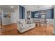 Beautiful living room with wood floors, white trim, chandelier, and blue accent wall with plenty of natural light at 101 Cambridge Way, Oxford, NC 27565